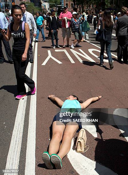 Woman lies down in the middle of busy George Street which was off limits to traffic during combined navies parade in the central business district of...