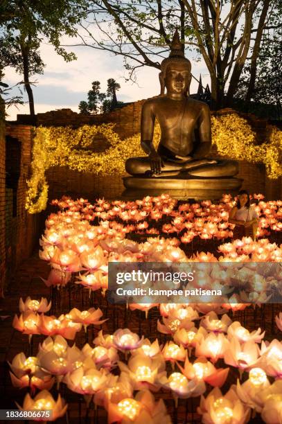 the beauty of sitting buddha statue with lighting decorated. abstract illuminated light festival background - religious icon stock pictures, royalty-free photos & images