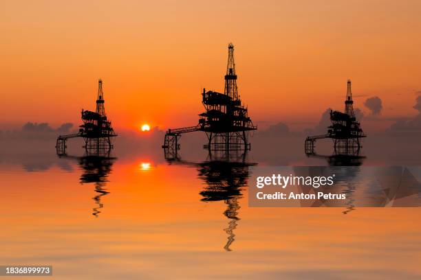 offshore oil rigs at sunset. world oil industry - oil stock pictures, royalty-free photos & images