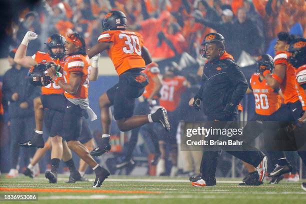 Wide receiver Brennan Presley and linebacker Collin Oliver of the Oklahoma State Cowboys rush onto the field after winning against the BYU Cougars in...