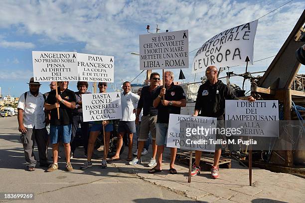 Activists protest at Lampedusa harbour during the visit of Manuel Barroso, President of the European Commission on October 9, 2013 in Lampedusa,...