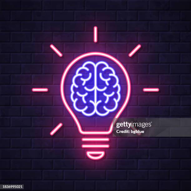 brain inside light bulb. glowing neon icon on brick wall background - neon lighting stock illustrations