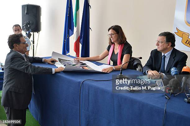 Rosario Crocetta looks at a poster showing pictures of immigrants to Cecilia Malmstrom, European Commisssioner as Manuel Barroso, President of the...