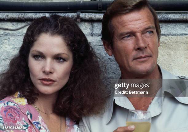 American actress Lois Chiles and British actor Roger Moore holding glasses of wine during a photo call to promote the film 'Moonraker' in Paris,...