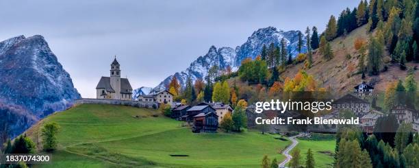 Panoramic view of the church Chiesa Santa Lucia in Colle Santa Lucia at the foot of Giau Pass, Passo di Giau, in autumn. The entire Dolomites are...