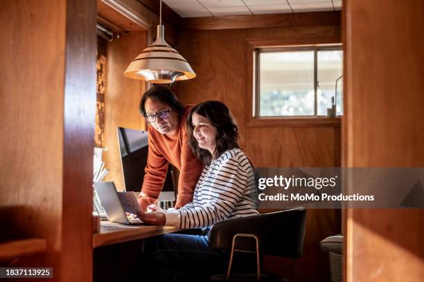 married couple using laptop and paying bills in home office - realism stock pictures, royalty-free photos & images