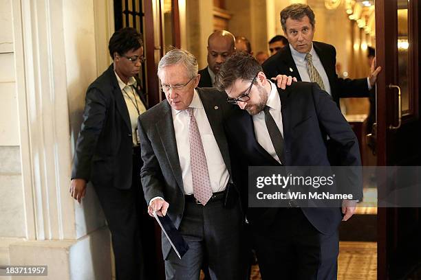 Senate Majority Leader Harry Reid speaks with his communications director Adam Jentleson as he walks to an event with Democratic senators on the...