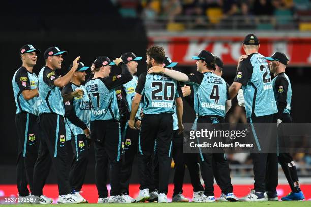Michael Neser of the Heat is congratulated by team mates after dismissing Sam Harper of the Stars during the BBL match between Brisbane Heat and...