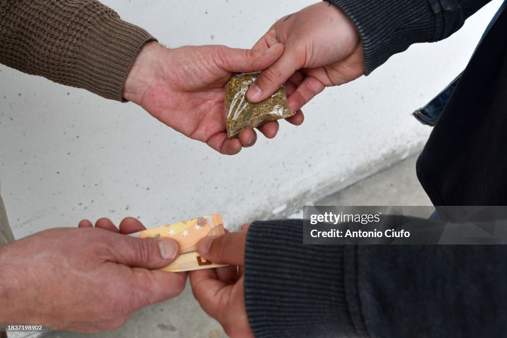 Pusher meets client on a street to sell him a few doses of hashish