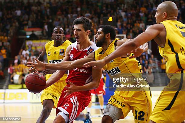 Nihad Djedovic of Muenchen is challenged by C.J. Harris and Shawn Huff of Ludwigsburg during the BBL match between MHP RIESEN Ludwigsburg and Bayern...