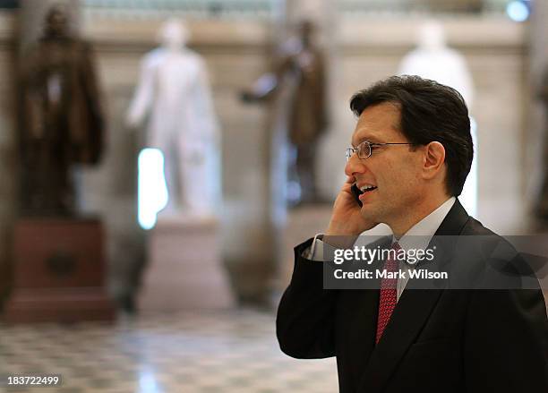 Majority Leader Eric Cantor talks on his phone as he walks through Statuary Hall at the U.S. Capitol, October 9, 2013 in Washington, DC. The U.S....