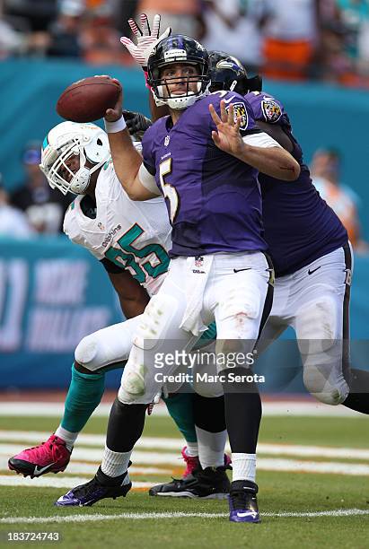 Quarterback Joe Flacco of the Baltimore Ravens throws under preasure against Dion Jordan of the Miami Dolphins at Sun Life Stadium on October 6, 2013...