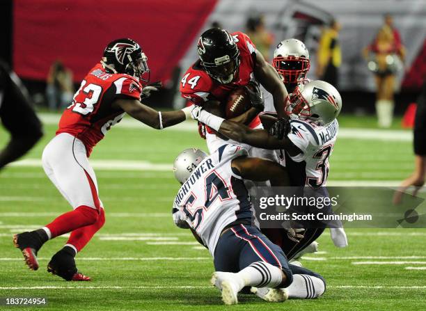 Jason Snelling of the Atlanta Falcons is tackled by Devin McCourty and Dont'a Hightower of the New England Patriots at the Georgia Dome on September...