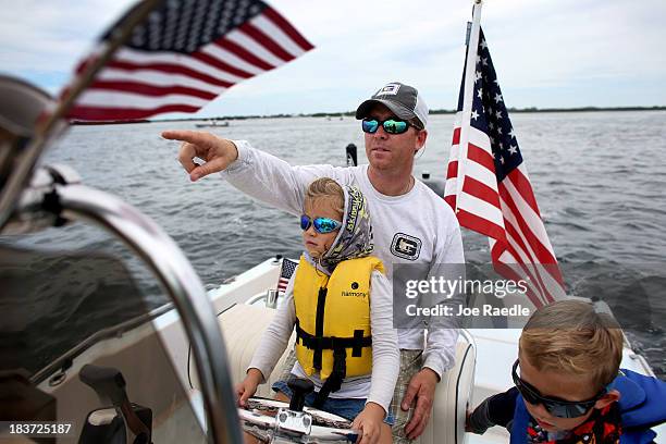 Fishing guide Captain Steve Friedman along with his children, Sidney Friedman and Benjamin Friedman participate in a floating protest asking the U.S....