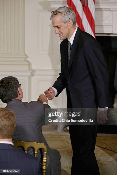 White House Chief of Staff Denis McDonough gives a fist-bump to Treasury Secretary Jack Lew before U.S. President Barack Obama announced his...