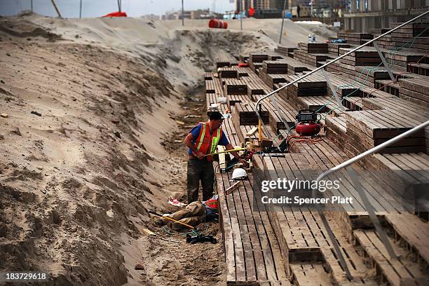 A worker makes modifications to a newly built pavilion at Rockaway beach on October 9, 2013 in the Queens borough of New York City. Nearly one year...