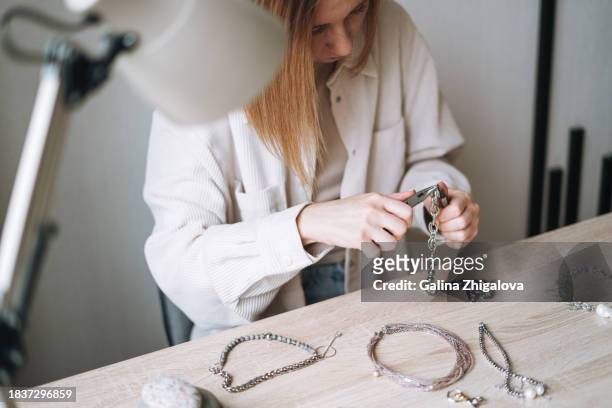 young woman jewelry designer creating necklace and working at table in the studio - white bead stock pictures, royalty-free photos & images