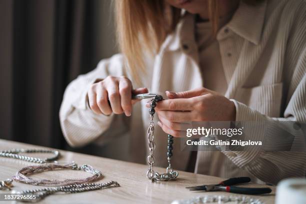 young woman jewelry designer creating necklace and working at table in the studio - white bead stock pictures, royalty-free photos & images