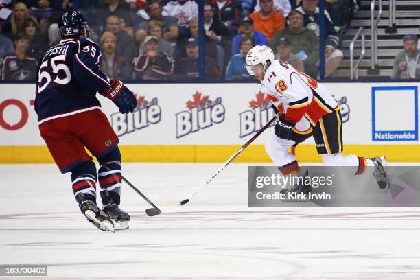 Ben Street of the Calgary Flames attempts to skate the puck past Mark Letestu of the Columbus Blue Jackets on October 4, 2013 at Nationwide Arena in...