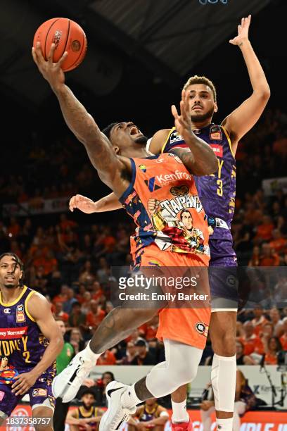 Patrick Miller of the Taipans goes to the basket under pressure form DJ Hogg of the Kings during the round 10 NBL match between Cairns Taipans and...