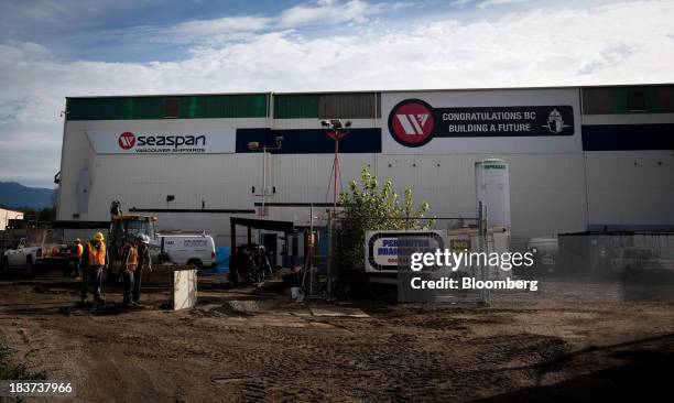 Construction workers past a building at the entrance to the Seaspan Vancouver Shipyard in North Vancouver, British Columbia, Canada, on Wednesday,...