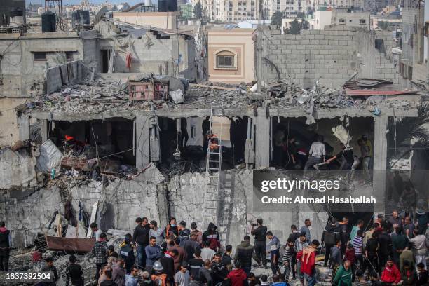 Palestinian citizens carry out search and rescue operations in the destruction caused by Israeli air strikes on December 07, 2023 in Khan Yunis,...