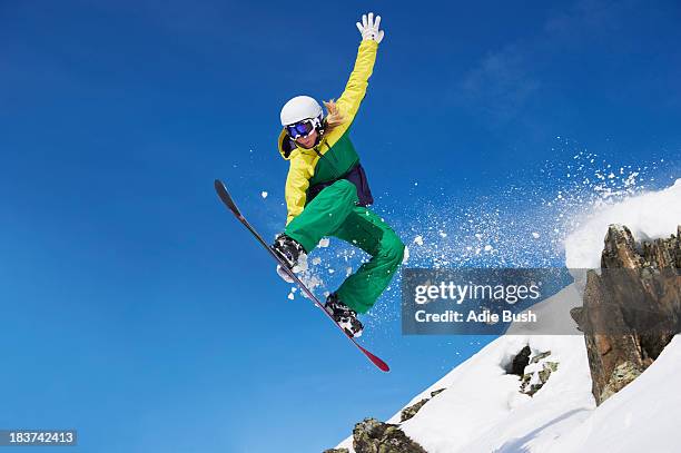 young female snowboarder jumping - snowboard stock-fotos und bilder