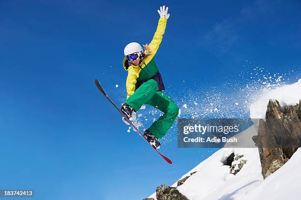 young female snowboarder jumping - ボード ストックフォトと画像