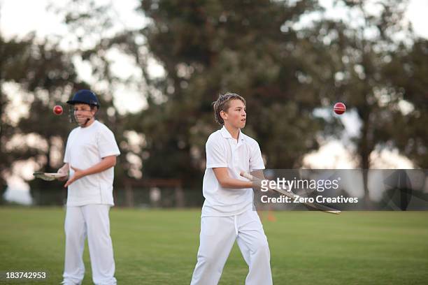 boys practising hitting cricket ball with bat - kids cricket stock pictures, royalty-free photos & images