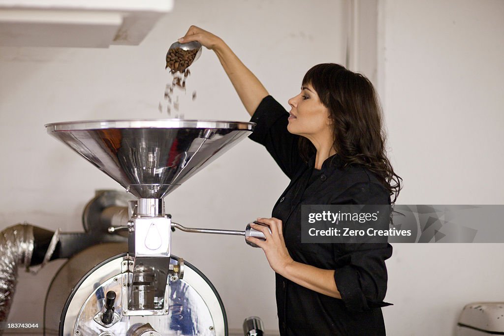 Woman pouring cocoa beans into funnel