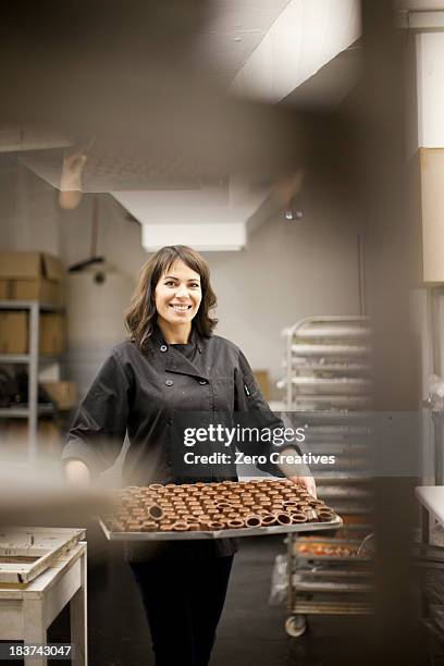 woman holding tray with chocolate - snoepwinkel stockfoto's en -beelden