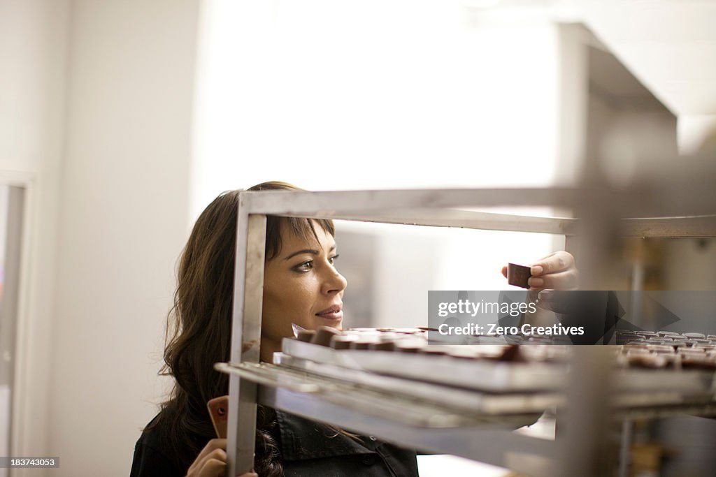 Woman inspecting chocolate in commercial kitchen