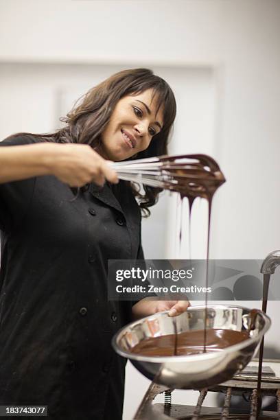 woman with mixing bowl and melted chocolate - liquid chocolate stock pictures, royalty-free photos & images