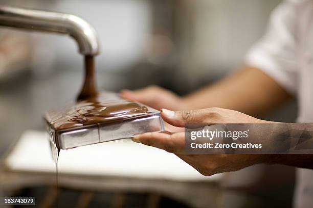 person filling mould with melted chocolate - chocolatier stock pictures, royalty-free photos & images