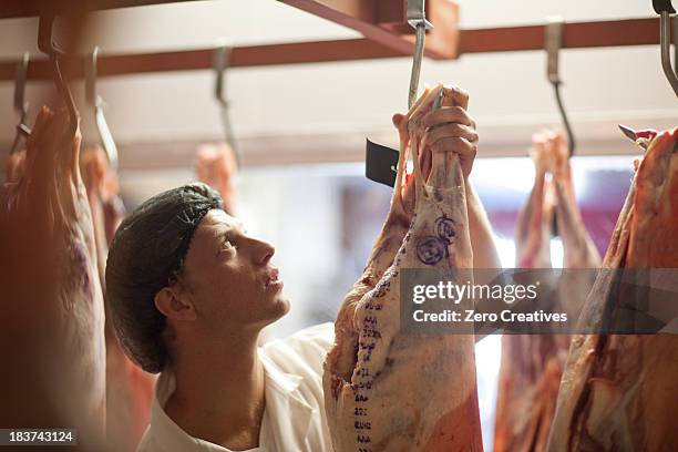 butcher inspecting meat - metzger stock-fotos und bilder