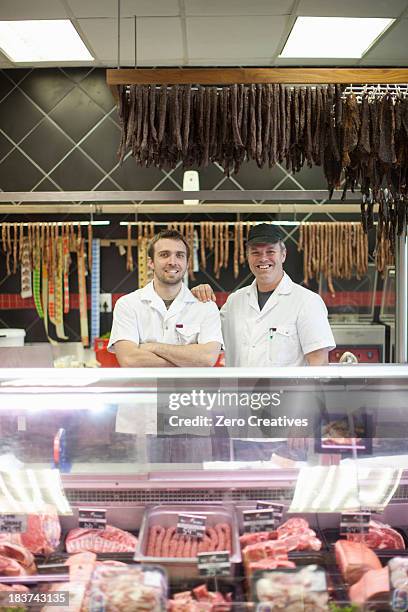 portrait of two male butchers in shop - butcher portrait imagens e fotografias de stock
