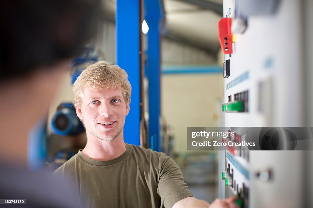 Man at control panel in olive processing plant