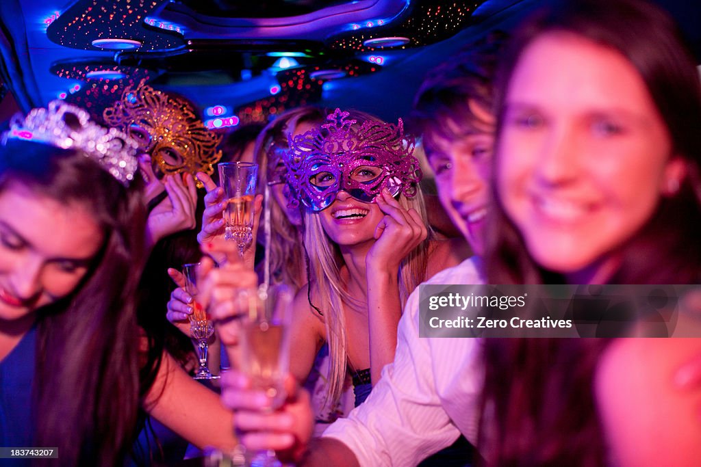 Young women wearing masks in limousine