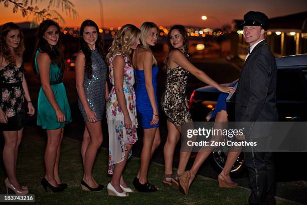 young women getting into limousine with chauffeur - prom limousine stock pictures, royalty-free photos & images