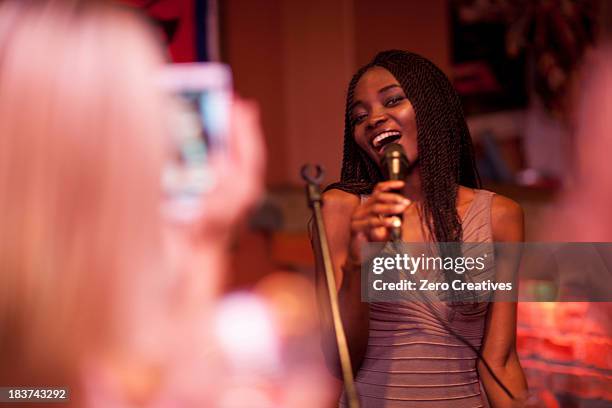 young woman singing with microphone - club singer fotografías e imágenes de stock