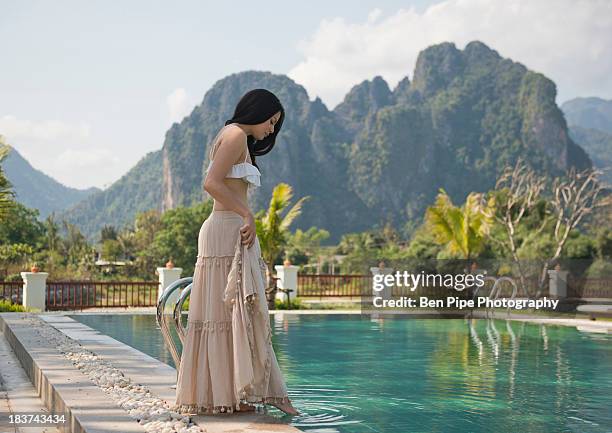 woman dipping toe in swimming pool, vang vieng, laos - dip toe stock pictures, royalty-free photos & images