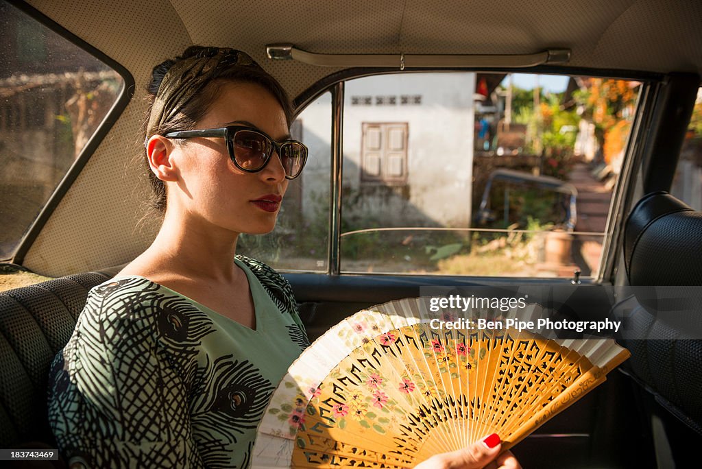 Woman in taxi holding fan