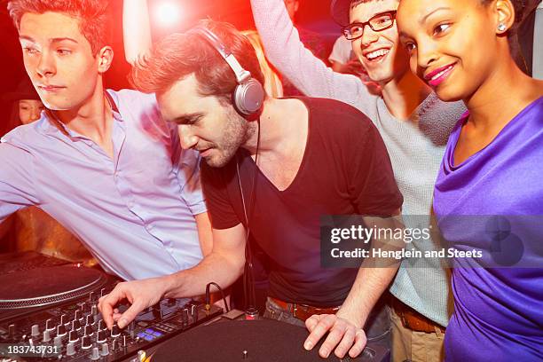 disc jockey with group of people behind mixing desk - party in munich stock pictures, royalty-free photos & images