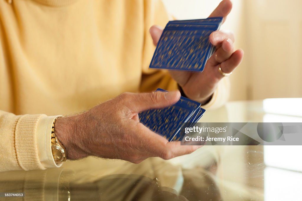 Close up of aged hands shuffling playing cards