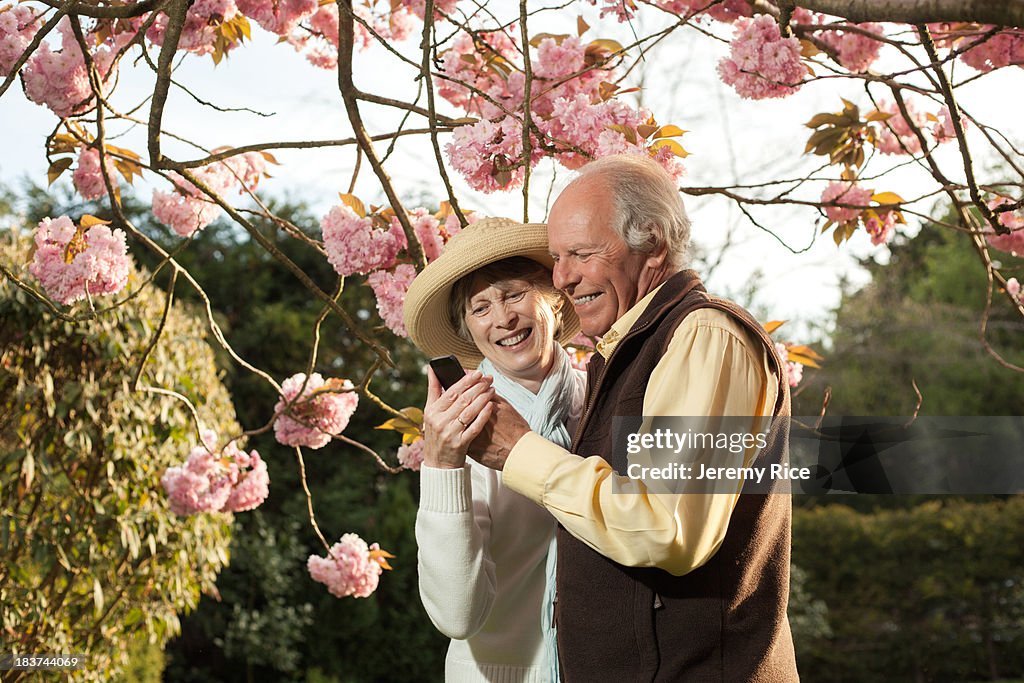 Senior couple smiling at message on mobile phone