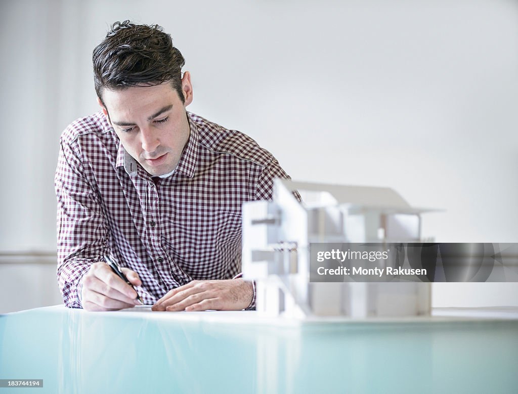 Architect working next to model building