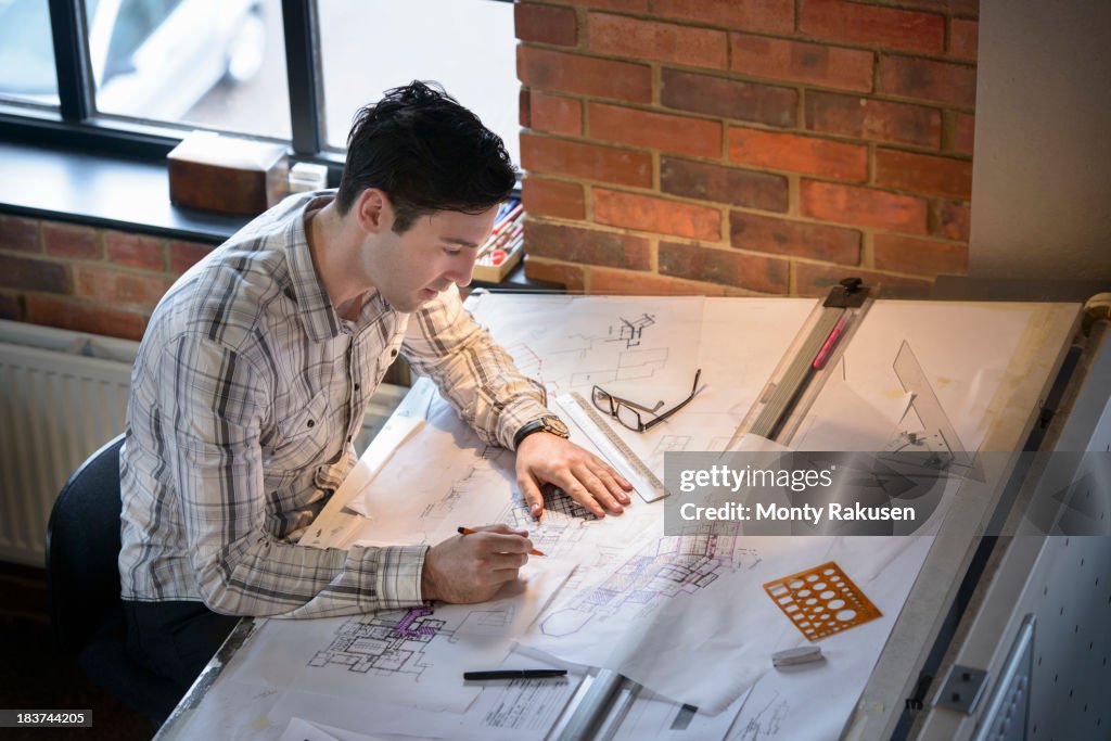 Architect drawing plans at drawing board
