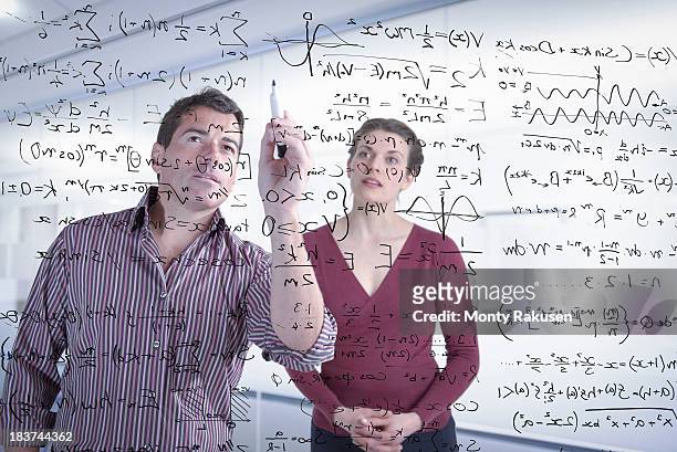 mathematicians writing complex scientific equations on screen - mathematician stock pictures, royalty-free photos & images
