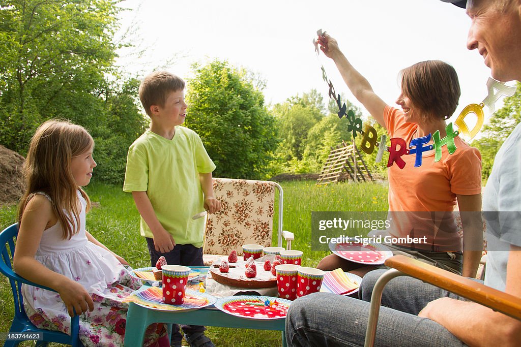 Family with two children celebrating birthday outdoors