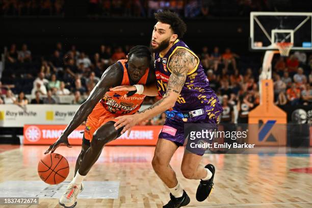 Bul Kuol of the Taipans drives up court under pressure from Denzel Valentine during the round 10 NBL match between Cairns Taipans and Sydney Kings at...